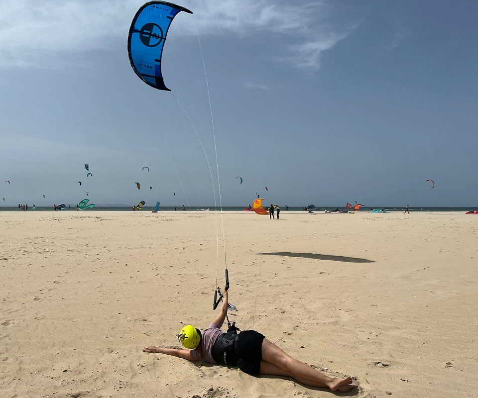 Alumna de kitesurf practicando el control de la cometa desde la arena en una playa de Tarifa.